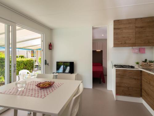 a kitchen and dining room with a table with a bowl of fruit on it at Holiday Home Garda Suite Deluxe by Interhome in Rivoltella