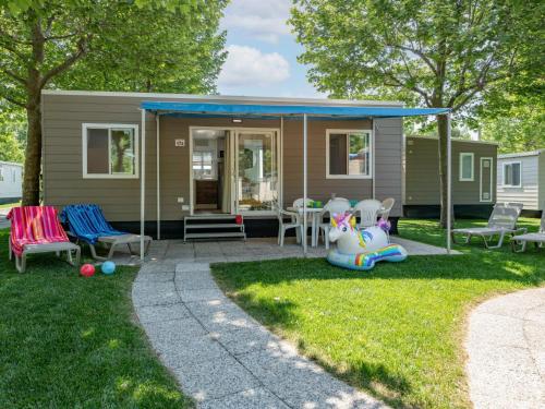 a tiny house with a porch and a patio at Holiday Home San Francesco Camping Village by Interhome in Rivoltella