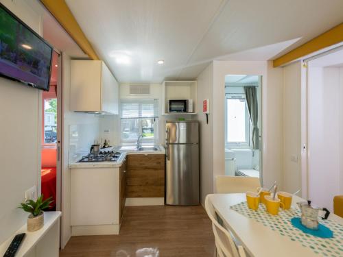 a small kitchen with a table and a refrigerator at Holiday Home San Francesco Camping Village by Interhome in Rivoltella