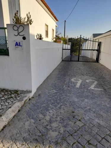 a gate to a house with an all sign on it at Hall 92 Quartos com WC em moradia com piscina A-das-Lebres Loures in Loures