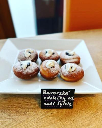 a plate of donuts on a table with a sign at Pension Pohoda in Malá Morávka