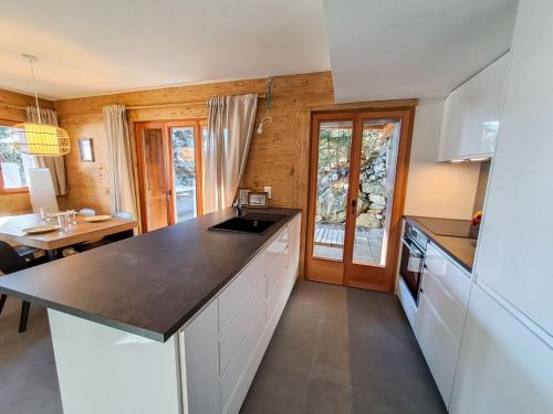 una cucina con armadi bianchi e piano di lavoro di Apartment Sernisa Rez by Interhome a Verbier