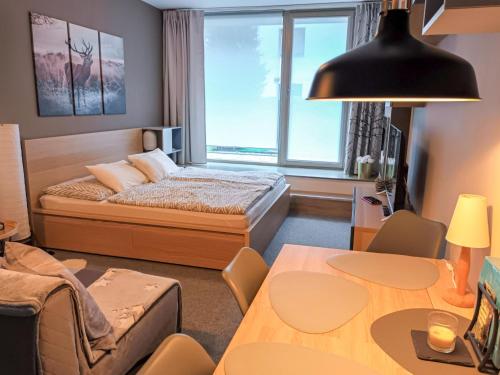 a bedroom with a bed and a table and a room at Studio Čertovka U jelena by Interhome in Harrachov