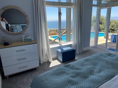 a bedroom with a bed and a view of a pool at Behrs Lair Luxury Villa Simons Town in Cape Town