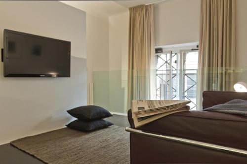 a bedroom with a bed and a flat screen tv at Suitime in Milan