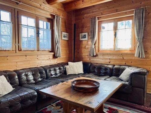 a living room with a leather couch and a table at Chalet Chalet Rodas 9 by Interhome in Malmigiuer