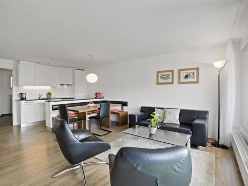 ein Wohnzimmer mit einem Sofa, Stühlen und einem Tisch in der Unterkunft Apartment Nr-78 Haus Ladina by Interhome in Lenzerheide