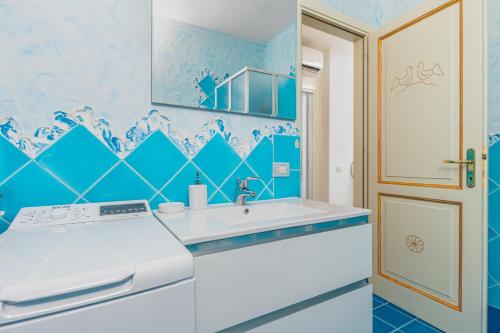 a blue and white kitchen with a sink at Casa Vacanze Lo Squalo in Olbia
