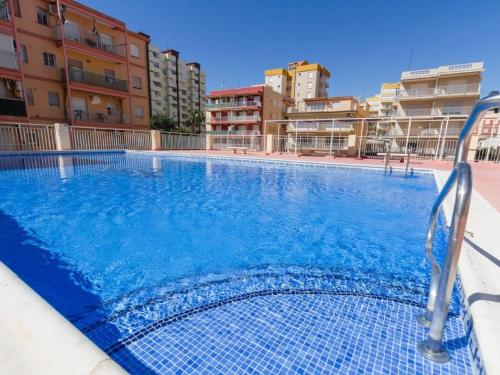 een zwembad met blauw water in een gebouw bij Apartment Ondina Plus by Interhome in Playa de Gandia