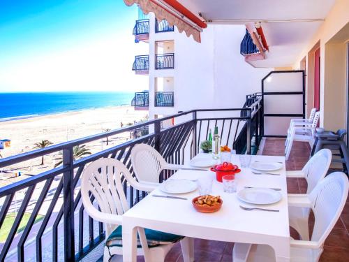 een witte tafel en stoelen op een balkon met uitzicht op het strand bij Apartment Ondina Plus by Interhome in Playa de Gandia