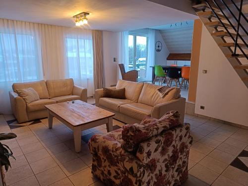 a living room with two couches and a table at Nimary Logies in Heusden - Zolder