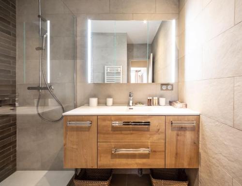 y baño con lavabo y ducha con espejo. en Appartement entièrement rénové avec Terrasse, en Saint-Tropez