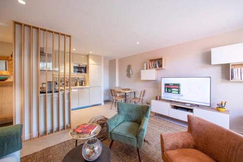 un salon avec un canapé et une télévision dans l'établissement Appartement entièrement rénové avec Terrasse, à Saint-Tropez