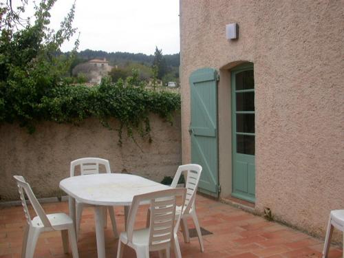 a table and chairs on a patio with a green door at Lou Jas, maison de charme, à 1 km de la mer in Cassis