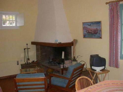 ein Wohnzimmer mit einem Kamin und einem TV in der Unterkunft Lou Jas, maison de charme, à 1 km de la mer in Cassis