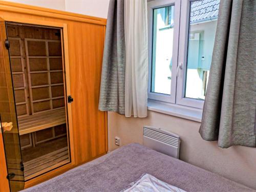 um quarto com uma janela, uma cama e uma janela em Holiday Home Lakeside Village 23 - - sauna by Interhome em Frymburk