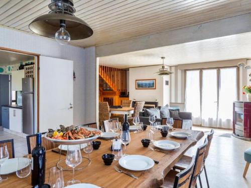 jadalnia z długim drewnianym stołem i miską jedzenia w obiekcie Holiday Home La Perle by Interhome w mieście Cancale