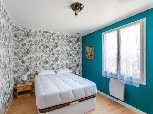 une chambre avec un lit et un mur bleu dans l'établissement Holiday Home La Perle by Interhome, à Cancale