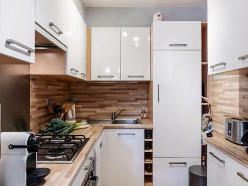 une cuisine avec des armoires blanches et un réfrigérateur blanc dans l'établissement Apartment Les Embruns-4 by Interhome, à Carnac