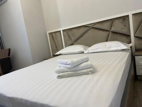 a bed with white towels on it with pillows at Family apartment 7 in Shymkent