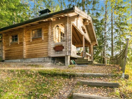 eine Blockhütte im Wald mit einer Veranda in der Unterkunft Holiday Home Lossitupa by Interhome in Iitti