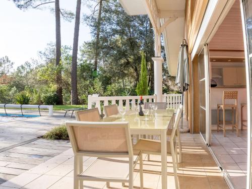 une table blanche et des chaises sur une terrasse dans l'établissement Holiday Home Atlantic Green by Interhome, à Lacanau-Océan