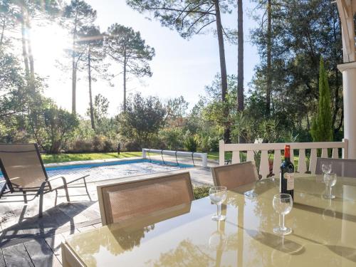 - une table avec des verres à vin sur une terrasse avec une piscine dans l'établissement Holiday Home Atlantic Green by Interhome, à Lacanau-Océan