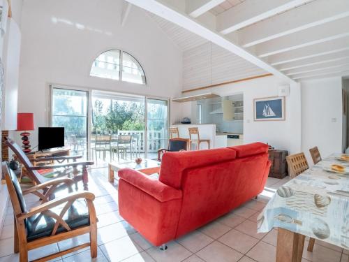 un salon avec un canapé rouge et une table dans l'établissement Holiday Home Atlantic Green by Interhome, à Lacanau-Océan