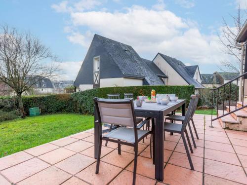 - une table et des chaises noires sur la terrasse dans l'établissement Holiday Home Le Vert Coteau-4 by Interhome, à Touques