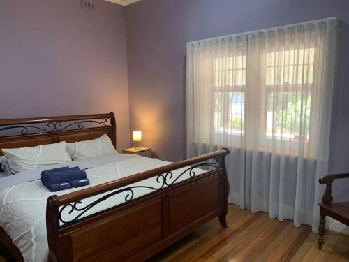 a bedroom with a large bed and a window at Botanic Bliss Bungalow in Adelaide