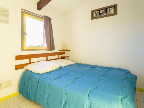 une chambre avec un lit bleu et une fenêtre dans l'établissement Holiday Home Les Captivantes II-8 by Interhome, au Cap d'Agde
