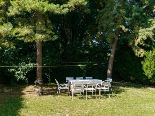 einen Tisch und Stühle in einem Garten mit Bäumen in der Unterkunft Apartment Bella 02 by Interhome in Balatonlelle