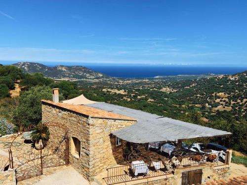 a stone building with a roof with a view of the ocean at VILLA BELLUCIA in Cateri