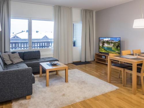 sala de estar con sofá, mesa y TV en Holiday Home Ruka ski chalets 64- 1302 by Interhome, en Ruka