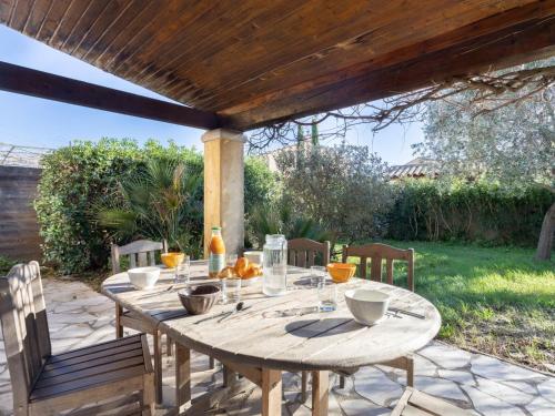 un tavolo e sedie in legno sotto un pergolato di Holiday Home Maison Cléo by Interhome a Cogolin