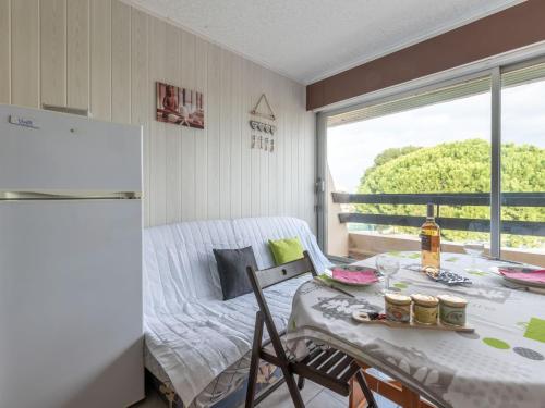 une petite cuisine avec une table et un réfrigérateur dans l'établissement Studio Escale Port-4 by Interhome, au Grau-du-Roi