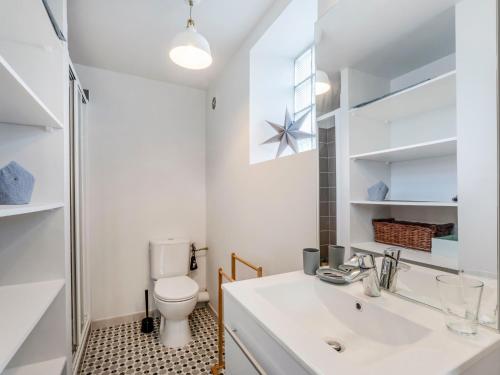 une salle de bain avec un lavabo blanc et des toilettes dans l'établissement Apartment Les Embruns-5 by Interhome, à Carnac