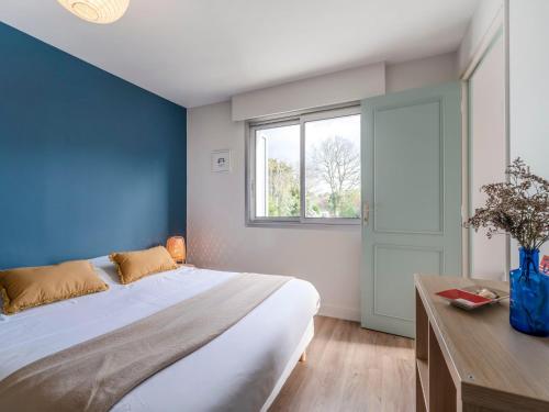a bedroom with a large bed and a window at Apartment Les Embruns-5 by Interhome in Carnac