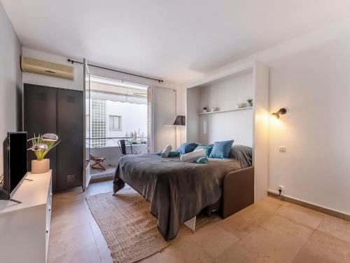 une chambre avec un lit avec des oreillers bleus et une télévision dans l'établissement Apartment Le Marlyne 2-3 by Interhome, à Cannes