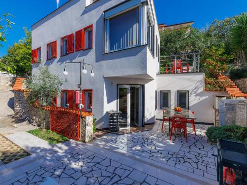 une maison blanche avec des portes rouges et une table dans l'établissement Holiday Home Villa Dragica by Interhome, à Labin