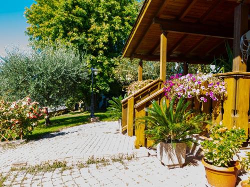 une terrasse couverte avec des fleurs en pots et une clôture dans l'établissement Chalet Del Colle by Interhome, à Pérouse