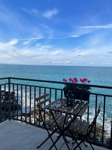 a table with flowers on a balcony overlooking the ocean at Terrazza Roberto in Cefalù