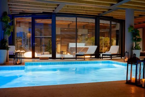 a large swimming pool in a building with windows at Hotel Veronesi La Torre in Dossobuono
