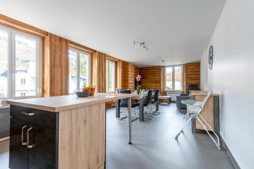 - une cuisine avec un comptoir, des chaises et des fenêtres dans l'établissement Ouréa - duplex avec balcon, à La Bresse