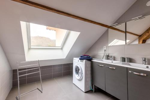a laundry room with a washing machine and a sink at Ouréa - duplex avec balcon in La Bresse