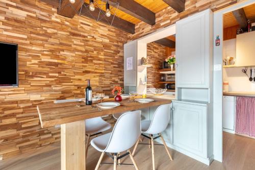 - une cuisine avec un mur en bois, une table et des chaises dans l'établissement Kioné - duplex avec terrasse, à La Bresse