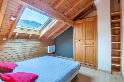 - une chambre avec un lit et une grande fenêtre dans l'établissement Kioné - duplex avec terrasse, à La Bresse