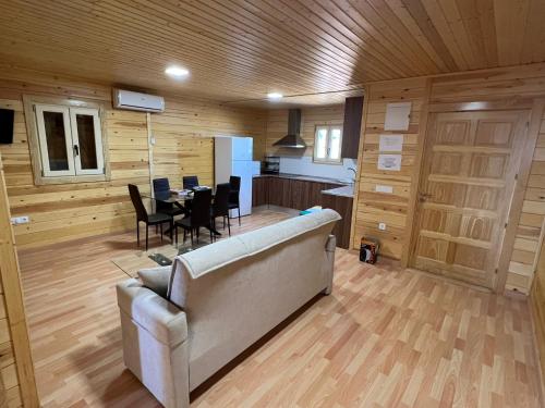 a living room with a couch and a table with chairs at La Dehesa Boyal II in Los Yébenes