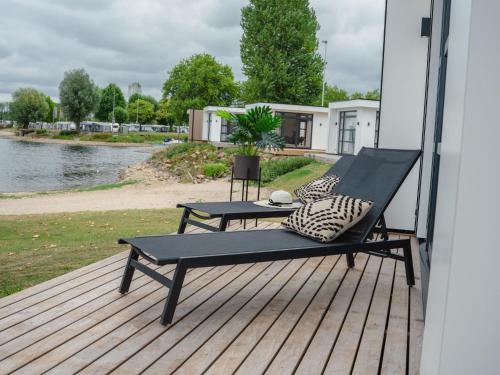 eine Bank auf einem Deck neben dem Wasser in der Unterkunft Holiday Home MarinaPark Bad Nederrijn-1 by Interhome in Maurik