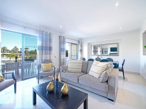 een woonkamer met een bank en een tafel bij Apartment Pine Hills Esmeralda by Interhome in Vilamoura